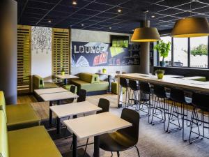 a restaurant with tables and chairs and a bar at ibis budget Stein Maastricht in Stein
