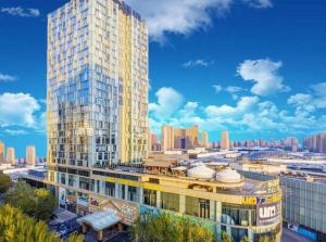 ein hohes Gebäude mitten in einer Stadt in der Unterkunft Pacific Regency Hotel Shenyang in Shenyang