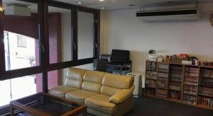 ein Wohnzimmer mit einer Couch und einem Bücherregal in der Unterkunft Hotel Town Nishikigawa in Kōchi + 87 Fotos
