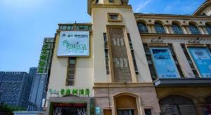 a building with a sign on the side of it at Vatica Lianyungang Haizhou Xinkong South Road Zhongyin Mingdu Hotel in Yuhang
