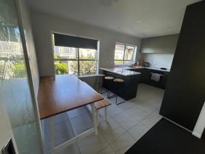 a kitchen with a wooden table and a counter top at Northcote holiday home- Next stop CBD in Auckland
