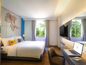 ein Hotelzimmer mit einem Bett und einem Schreibtisch mit einem Laptop in der Unterkunft ibis Styles Siem Reap in Siem Reap