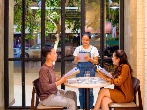 eine Gruppe von Menschen, die um einen Tisch herum sitzen in der Unterkunft ibis Styles Siem Reap in Siem Reap + 71 Fotos