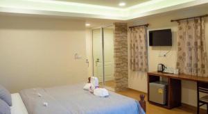 - un petit enfant assis sur un lit dans une chambre dans l'établissement The Vintage Residence, à Ban Thung Sukla 54 autres photos