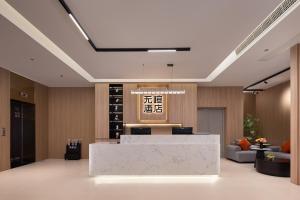 Un vestíbulo con mostrador de recepción en un edificio. en Wuxuan Hotel Zoo Branch, en Chongqing