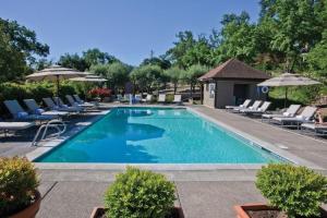 une piscine avec chaises et parasols dans un hôtel dans l'établissement Wine Country Inn & Cottages Napa Valley, à Barro