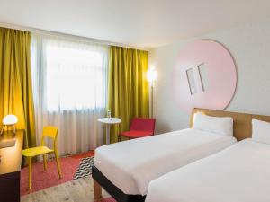 布隆ibis Styles Lyon Bron Eurexpo的有两张床和一张桌子的酒店房间