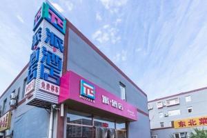 un bâtiment avec une enseigne sur le côté dans l'établissement PAI Hotel Beijing Capital International Airport Linhe Development Zone, à Tahe