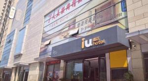 a building with a sign on the side of it at IU Hotels·Hefei Lujiang Andeli Plaza in Lujiang