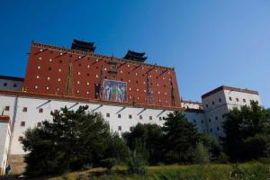 un grand bâtiment avec une fresque murale sur son côté dans l'établissement James Joyce Coffetel·Chengde Mountain Resort Toudao Pailou, à Chengde