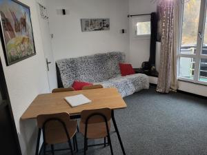 a living room with a table and a bed at Studio Le Boussolenc in Les Orres
