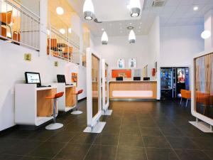 um átrio de uma clínica com mesas e cadeiras em ibis budget Patos de Minas em Patos de Minas
