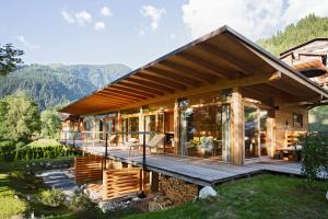 a house in the mountains with a large deck at Alpenlofts in Bad Gastein