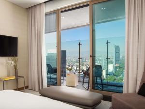 a bedroom with a large window with a view of a city at Sofitel Mexico City Reforma in Mexico City