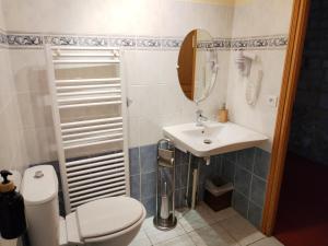 un baño con inodoro y lavabo en Auberge, en Mello