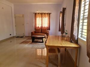 a living room with a table and a couch at Starlight Manor Mavallipura in Bangalore