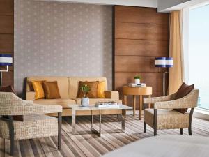 a living room with a couch and chairs at Pullman Doha West Bay in Doha