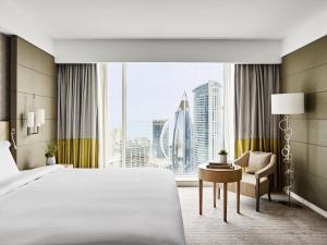 a hotel room with a bed and a desk and a window at Pullman Doha West Bay in Doha +218 photos