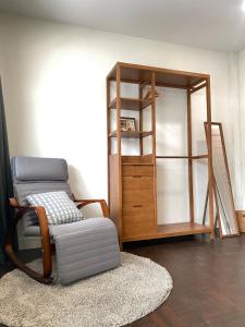 - un salon avec une chaise et une étagère dans l'établissement Central Nakhon Pathom 2BR Townhouse with AC & Kitchen, à Nakhon Pathom