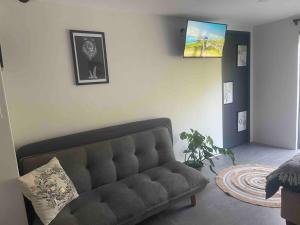 a living room with a couch and a tv on the wall at Three Waves in Ballito