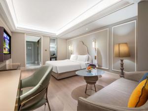 平阴山东平阴美居酒店的一间酒店房间，里面有一张床和一张沙发 更多77张照片