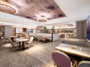 平阴山东平阴美居酒店的一家有桌椅和酒吧的餐厅