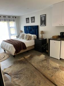 a bedroom with a large bed with a blue headboard at Three Waves in Ballito