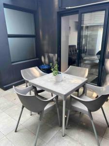 a table and chairs with a potted plant on it at Three Waves in Ballito