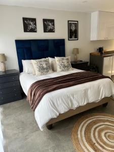 a bedroom with a large bed with a blue headboard at Three Waves in Ballito