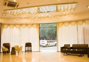 ein Wohnzimmer mit Möbeln und einem großen Fenster in der Unterkunft Borrman Hotel Shaoguan Century East Street Fengcai Building in Shaoguan