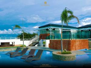 a resort with a swimming pool with a palm tree at Belajandro Hotel Angeles City in Angeles