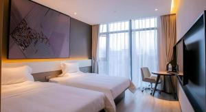 une chambre d'hôtel avec deux lits et une télévision à écran plat dans l'établissement IU Hotel Suizhou Shunjing Avenue Passenger Transportation Center, à Suizhou 24 autres photos