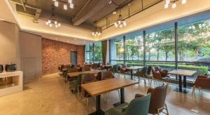 une salle à manger avec tables, chaises et fenêtres dans l'établissement James Joyce Coffetel Tianjing First Central Hospital Nankai University, à Tianjin