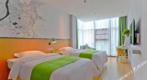 une chambre d'hôtel avec trois lits et une carte au mur dans l'établissement Vatica Hotel Hefei Yaohai Longgang Subway Station, à Hefei 99 autres photos