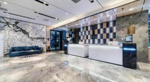 un salon avec un canapé bleu et une table dans l'établissement Echarm Hotel Nanjing Lishui High-speed Railway Station Wuzhou Commercial City, à Lishui