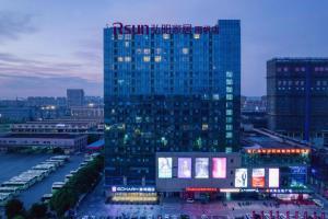 un grand bâtiment avec une enseigne au sommet dans l'établissement Echarm Hotel Nanjing Lishui High-speed Railway Station Wuzhou Commercial City, à Lishui