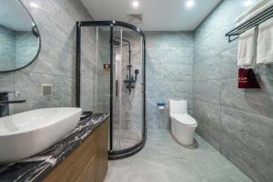 een badkamer met douche, wastafel en toilet bij Phoenix Geometry Light Accommodation in Fenghuang +114 foto's