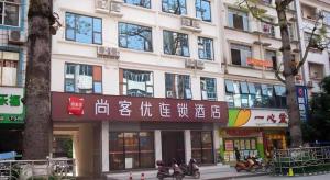 Un grand bâtiment avec des motocycles devant lui dans l'établissement Thank Inn Hotel Guangxi Hechi Yizhou Sankeshu, à Qingyuan