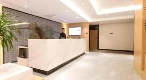 Ein Mann steht hinter einem Tresen in einer Lobby. in der Unterkunft Green Tree Inn Nanchang Zhongshan Road Bayiguan in Nanchang