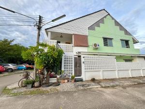 a green and white house with a fence at D sleep Home Chiangmai in Chiang Mai