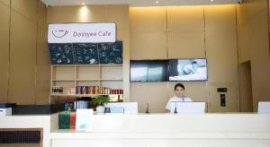 a woman is sitting at a counter in a coffee shop at City Comfort Inn Huaihua East Station in Huaihua