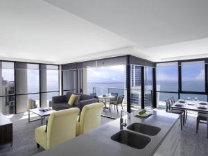 a living room with a couch and tables and chairs at Mantra Circle On Cavill in Gold Coast