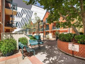 un parc avec deux bancs bleus et des bâtiments dans l'établissement BreakFree Adelaide, à Adélaïde