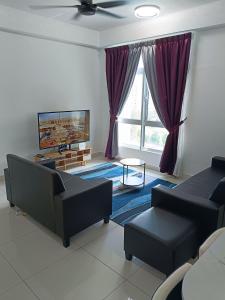 a living room with two couches and a tv at Alstenor Homestay 2 in Kajang