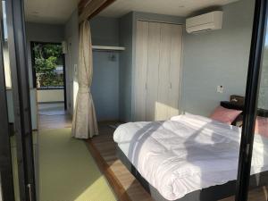 a bedroom with a white bed and a window at Villa resort -悠- in Miyakojima