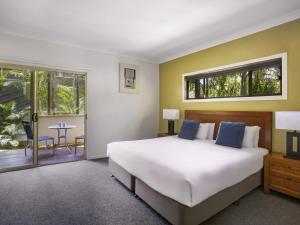 a bedroom with a large bed and a balcony at BreakFree Aanuka Beach Resort in Coffs Harbour +40 photos