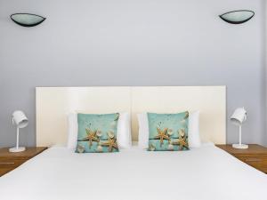 a bedroom with a white bed with pillows at BreakFree Royal Harbour in Cairns +49 photos