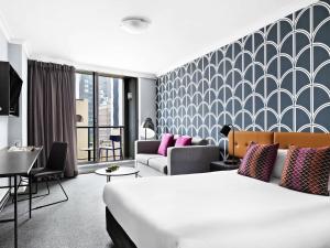 una habitación de hotel con una cama y un sofá en Mantra Sydney Central, en Sídney