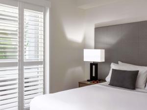 a bedroom with a white bed and a window at Mantra Aqueous on Port in Port Douglas +75 photos
