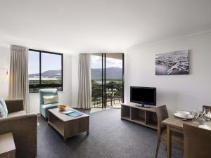 a living room with a couch and a tv at Mantra Esplanade in Cairns
